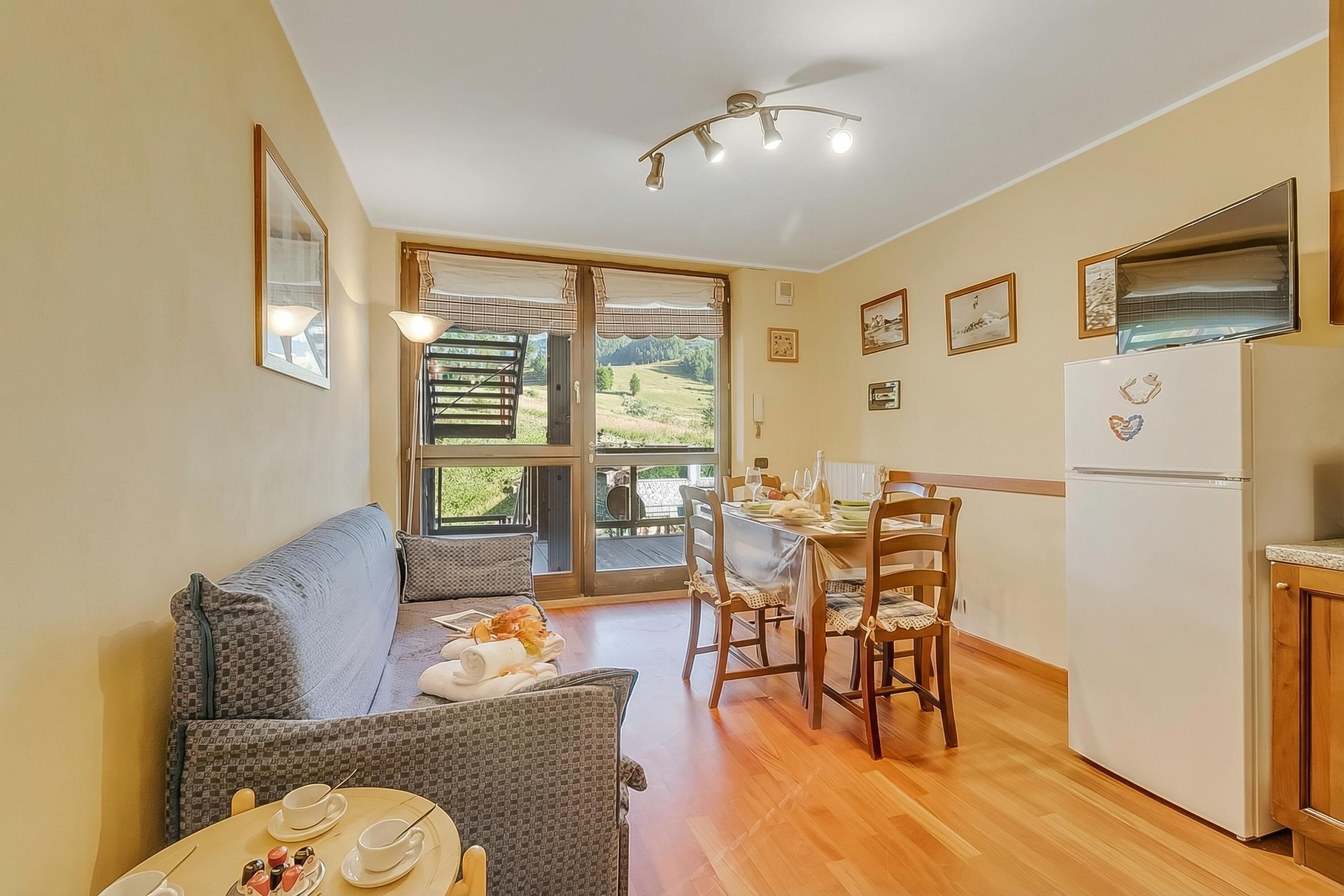 Une pièce confortable avec un canapé, une table à manger, des chaises et un coin cuisine.