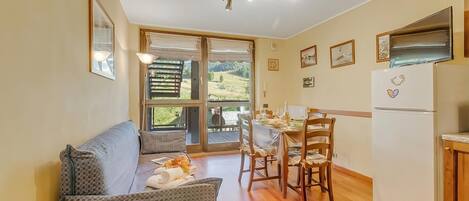 Une pièce confortable avec un canapé, une table à manger, des chaises et un coin cuisine.