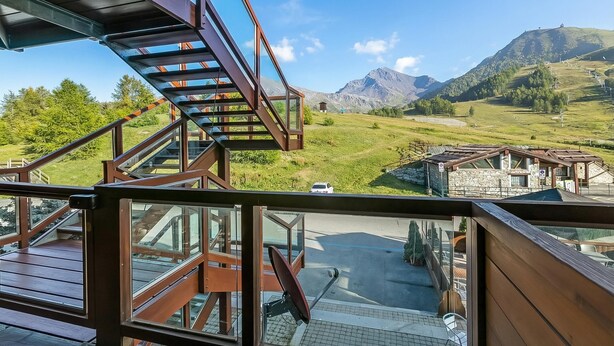 A view from a balcony with a staircase leading to a deck, overlooking a mountainous landscape with a clear sky. - Appartamento Tracce Di Neve With Parking for 4 (Sestriere)
