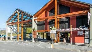 A building with a ski service shop, a bike rental sign, and a covered area with a glass roof. - Appartamento Tracce Di Neve With Parking for 4 (Sestriere)