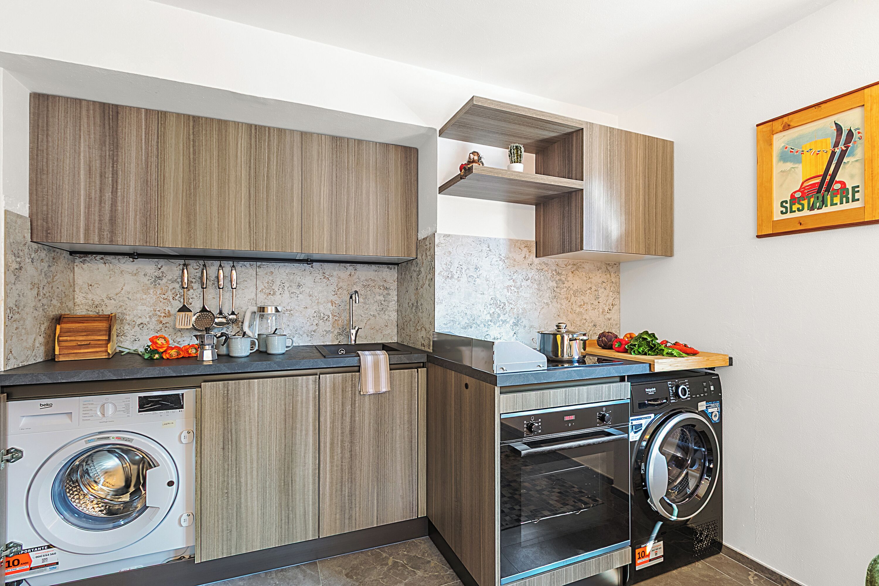 Una cocina compacta con electrodomésticos integrados, armarios de madera y una pequeña encimera.