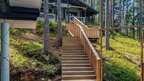 A wooden staircase leading to a cabin in a forested area. - Villa norppa by Interhome (Punkaharju)