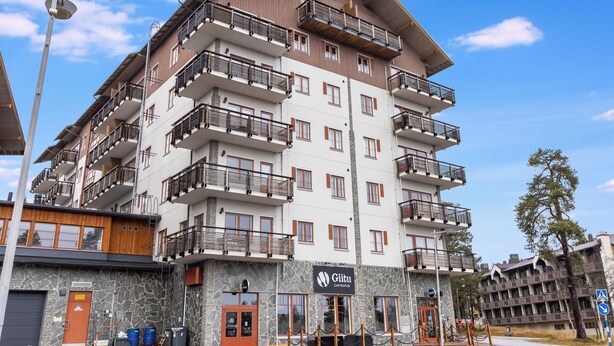Ein mehrgeschossiges Hotel mit Balkonen, einer Steinaußenfassade und einem Schild mit der Aufschrift 'Gliitu Castropub'.