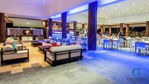 A spacious lobby with seating areas, a bar, and a fireplace. - Gerizim Hotel Resort (Chaung Thar)