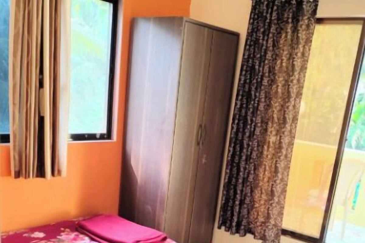 Une chambre avec un lit, une armoire et une fenêtre avec des rideaux.