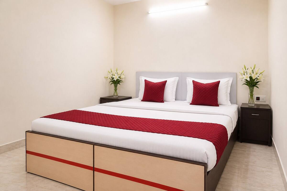 A neatly arranged hotel room with a bed, bedside tables, and a nightstand.