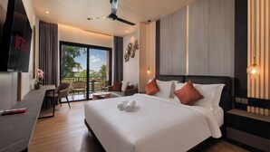 A modern hotel room with a large bed, a desk, and a balcony with a view. - Amankara Canggu (Tibubeneng)