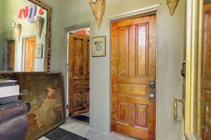 A hallway with wooden doors, a large mirror, and a framed picture on the wall. - Heart of St Louis! Walkable Soulard Apt w/ Loft (St. Louis)