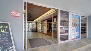 Une devanture de magasin avec une enseigne indiquant « Hawaiian King » et une publicité pour la bière Budweiser.