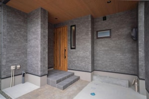 Une salle de bain avec une baignoire, une porte en bois et une petite fenêtre.