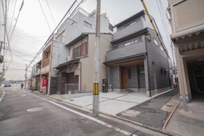 Une rue résidentielle bordée de maisons, avec un trottoir et des poteaux électriques.