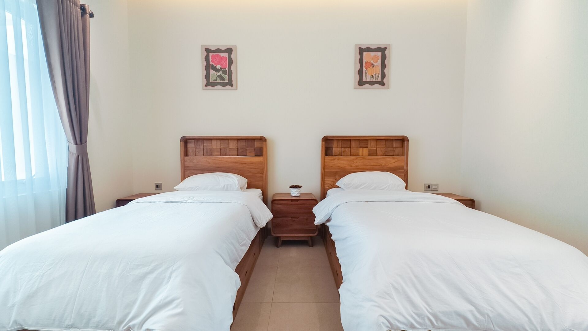 A double room with two beds, a nightstand between them, and a small table.