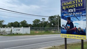A signboard advertising a homestay with contact numbers and a boat trip option. - OYO 91250 Roomstay Awie (Setiu)