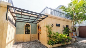 A building with a tiled courtyard, a covered entrance, and a metal fence. - La Jolla Canggu (Canggu)