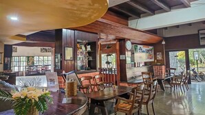 Een restaurant met houten meubels, een balie en uitzicht op de omgeving.
