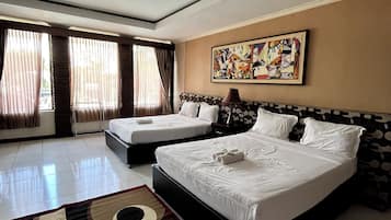 A hotel room with two beds, a large abstract painting, and a patterned rug.
