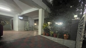 Un espacio interior amplio con suelo de baldosas, plantas en macetas y una escalera.