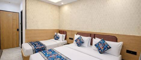A hotel room with two beds, a ceiling fan, and a door.