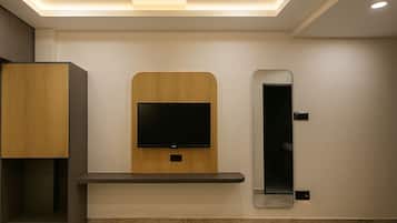 Un baño moderno con televisión integrada, un espejo y un armario de madera.