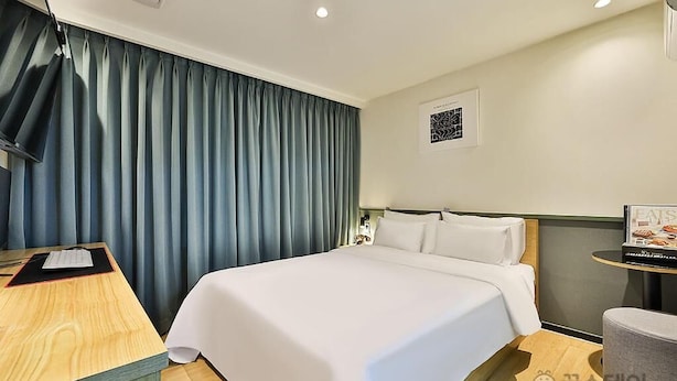 A hotel room with a large bed, a desk, and a chair. - NO25 HOTEL BUPYEONG (Incheon)
