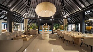 A spacious indoor area with a high ceiling, a central round table, and seating arrangements. - Des Indes II by Elite Havens (Kabupaten Badung)