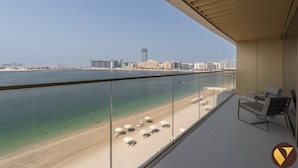 A balcony with a view of a beach and cityscape. - Vogue| Grand Blue Beachfront Designed By Elie Saab (Dubai)