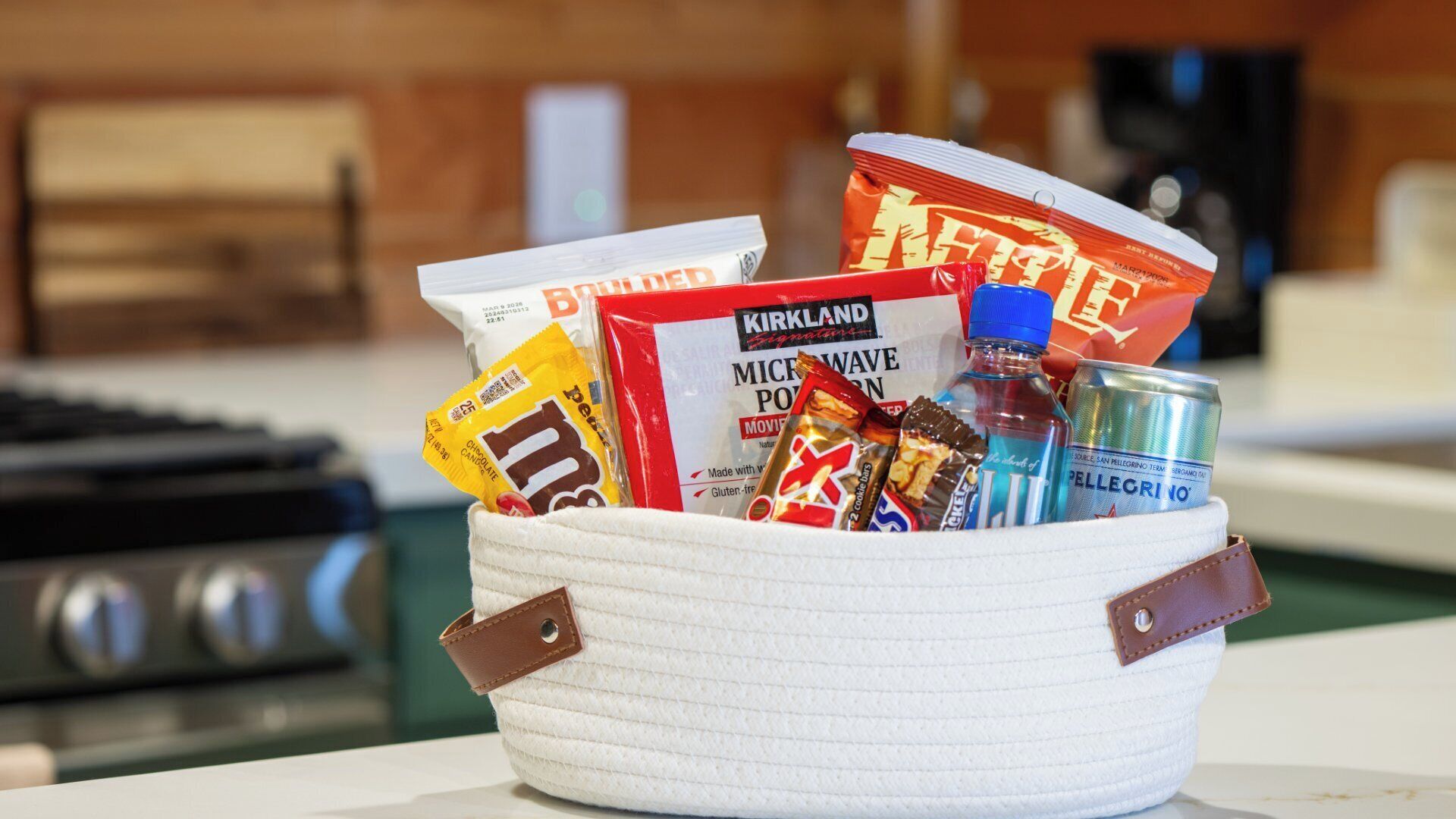 A basket containing various food items and a can of Pellegrino water.