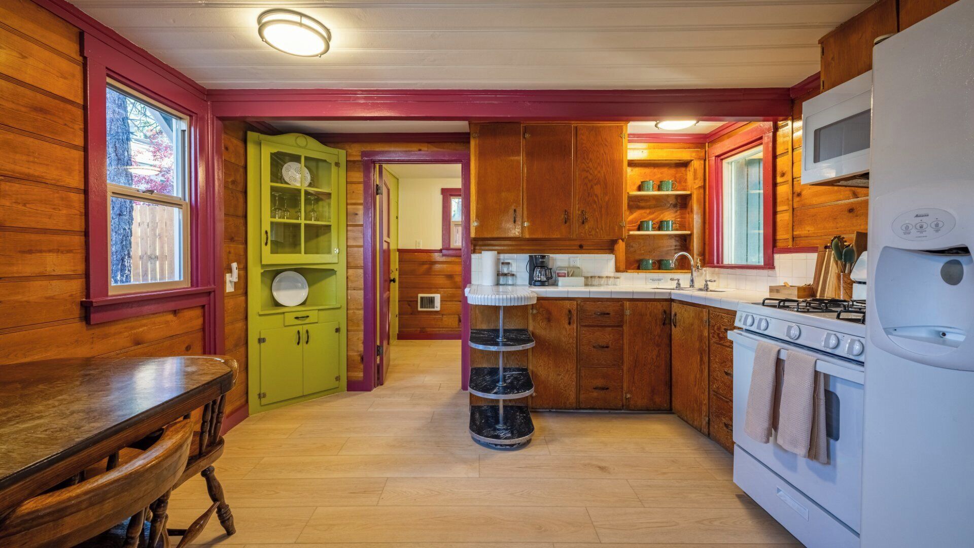 A compact kitchen with wooden cabinets, a central island, and a white refrigerator.