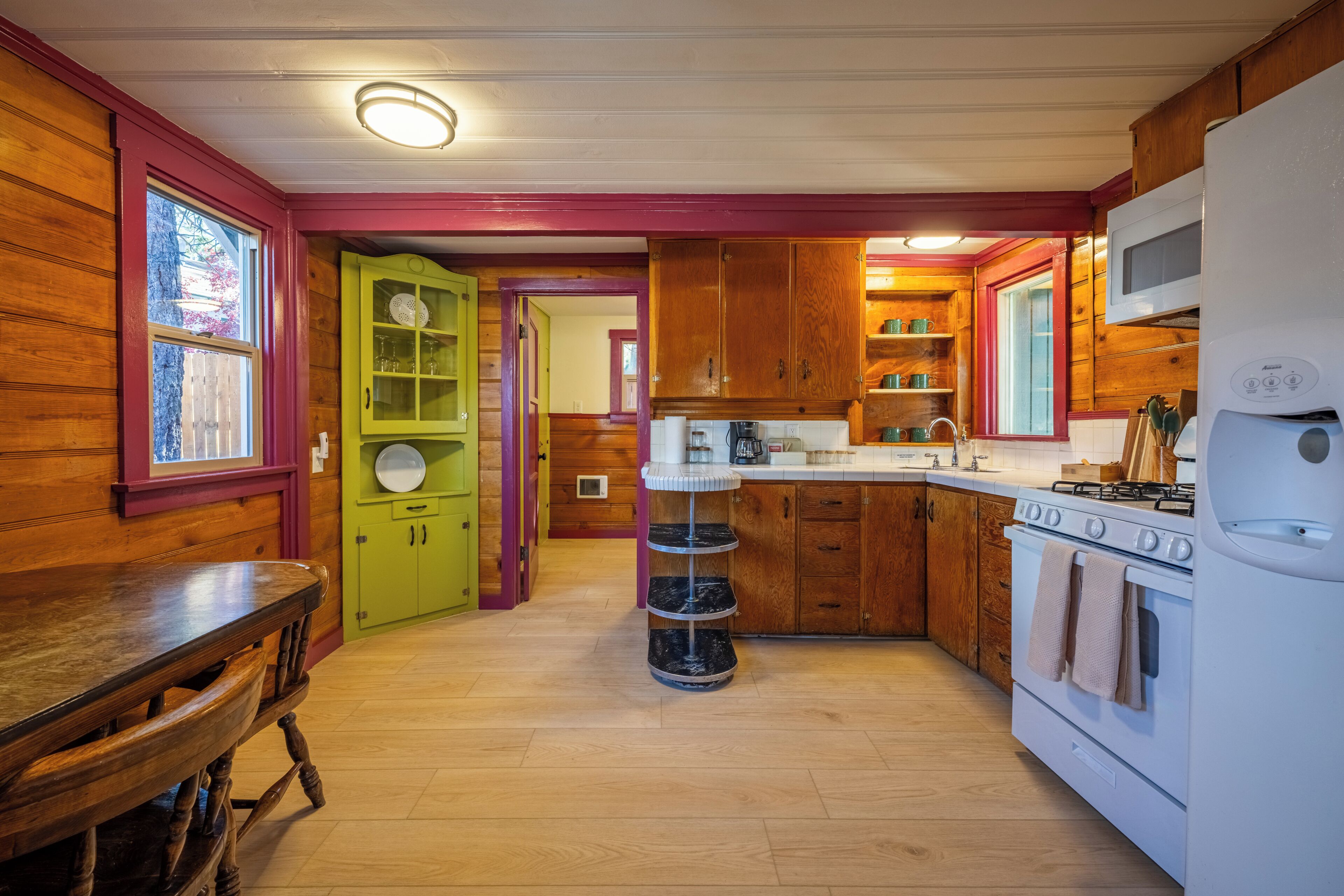 A kitchen with wooden cabinets, a stove, and a dining table.
