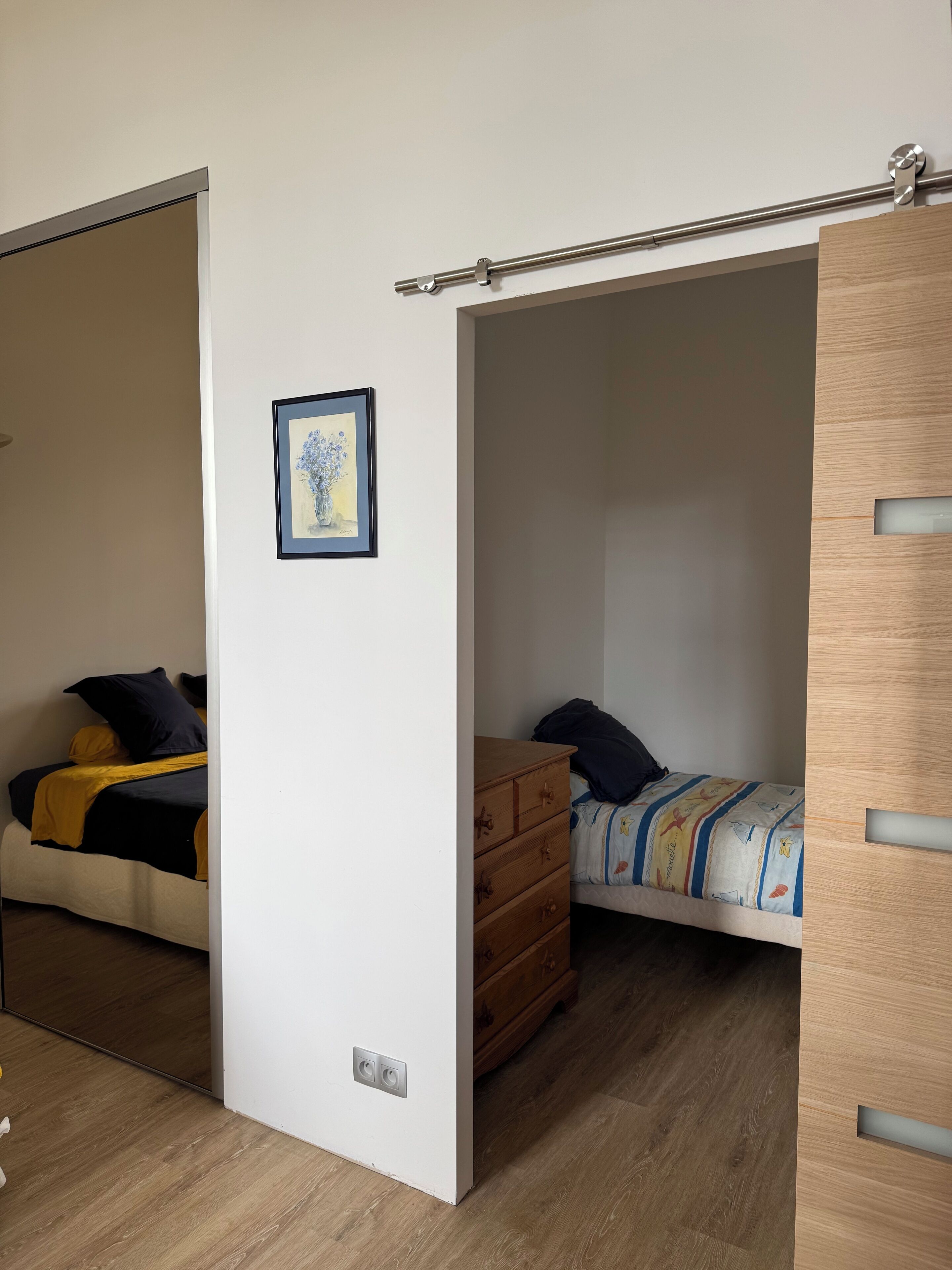 Un dormitorio con una cama, un aparador y un armario de madera.