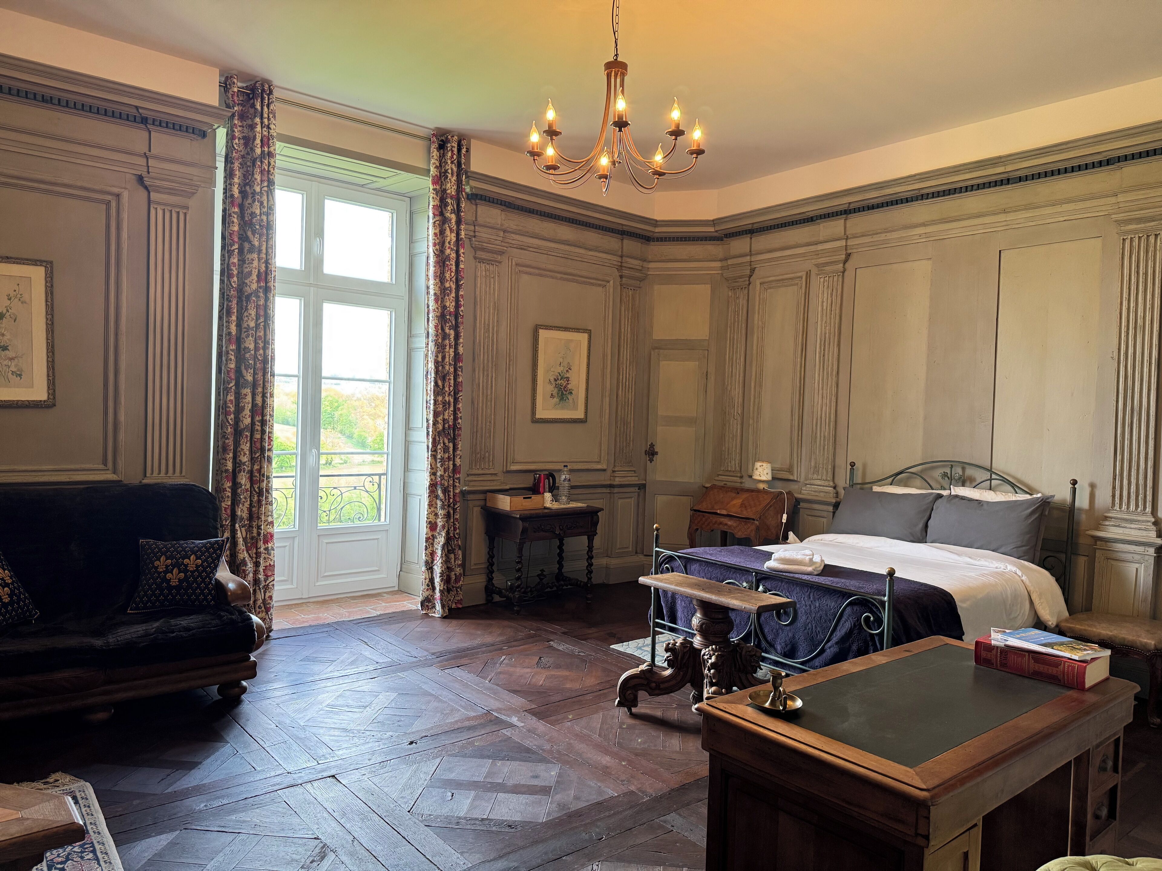 Une chambre classique avec un lit, un bureau, une chaise et un canapé.