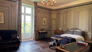 Une chambre classique avec un lit, un bureau, une chaise et un canapé.