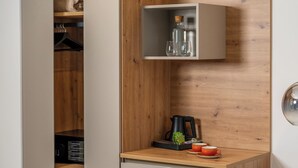 A compact room with a built-in wardrobe, a small kitchenette, and a seating area. - Landhouse Bled (Bled)