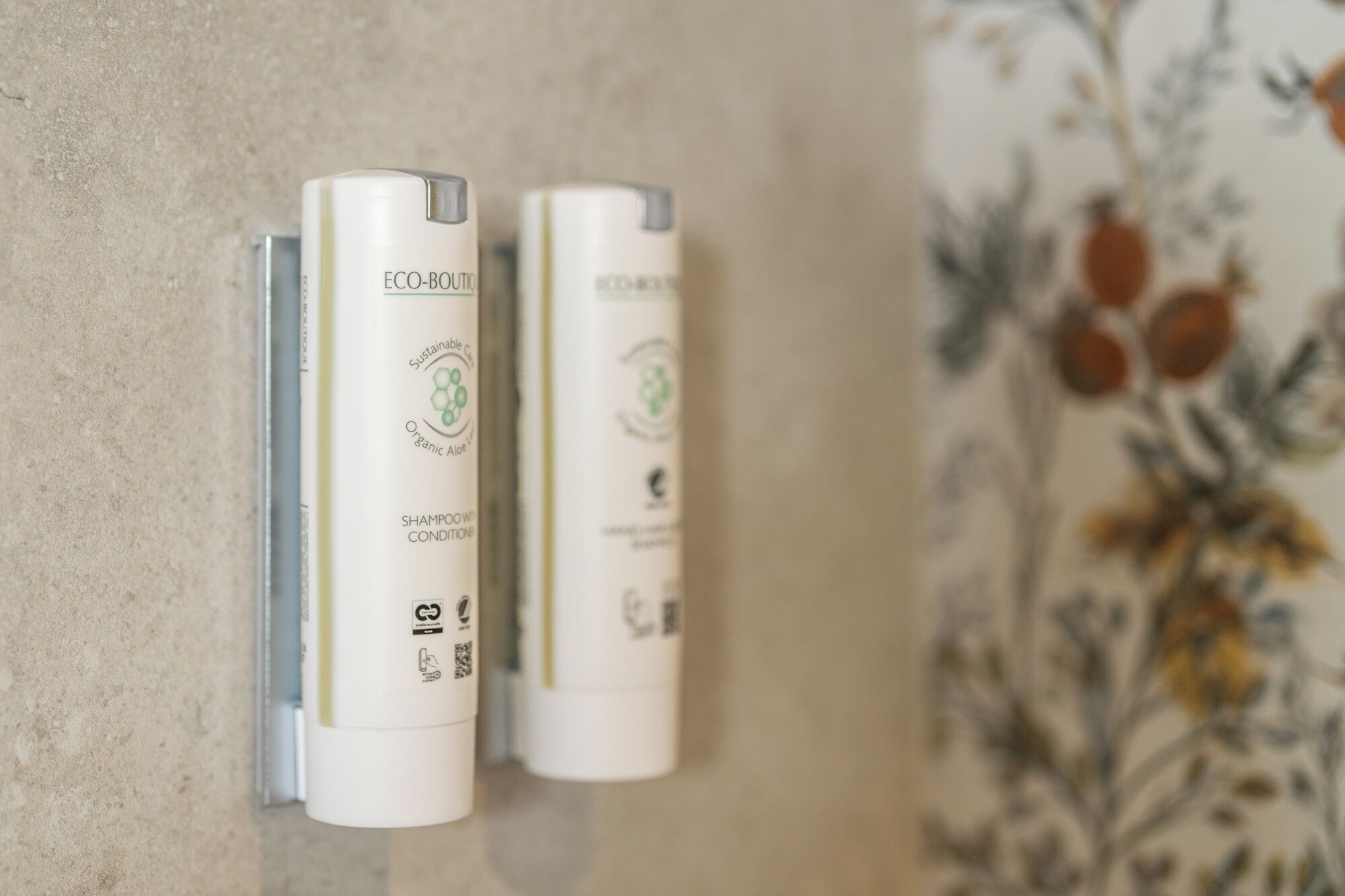 Two white bottles labeled "ECO-BOUTIQUE" on a textured wall.