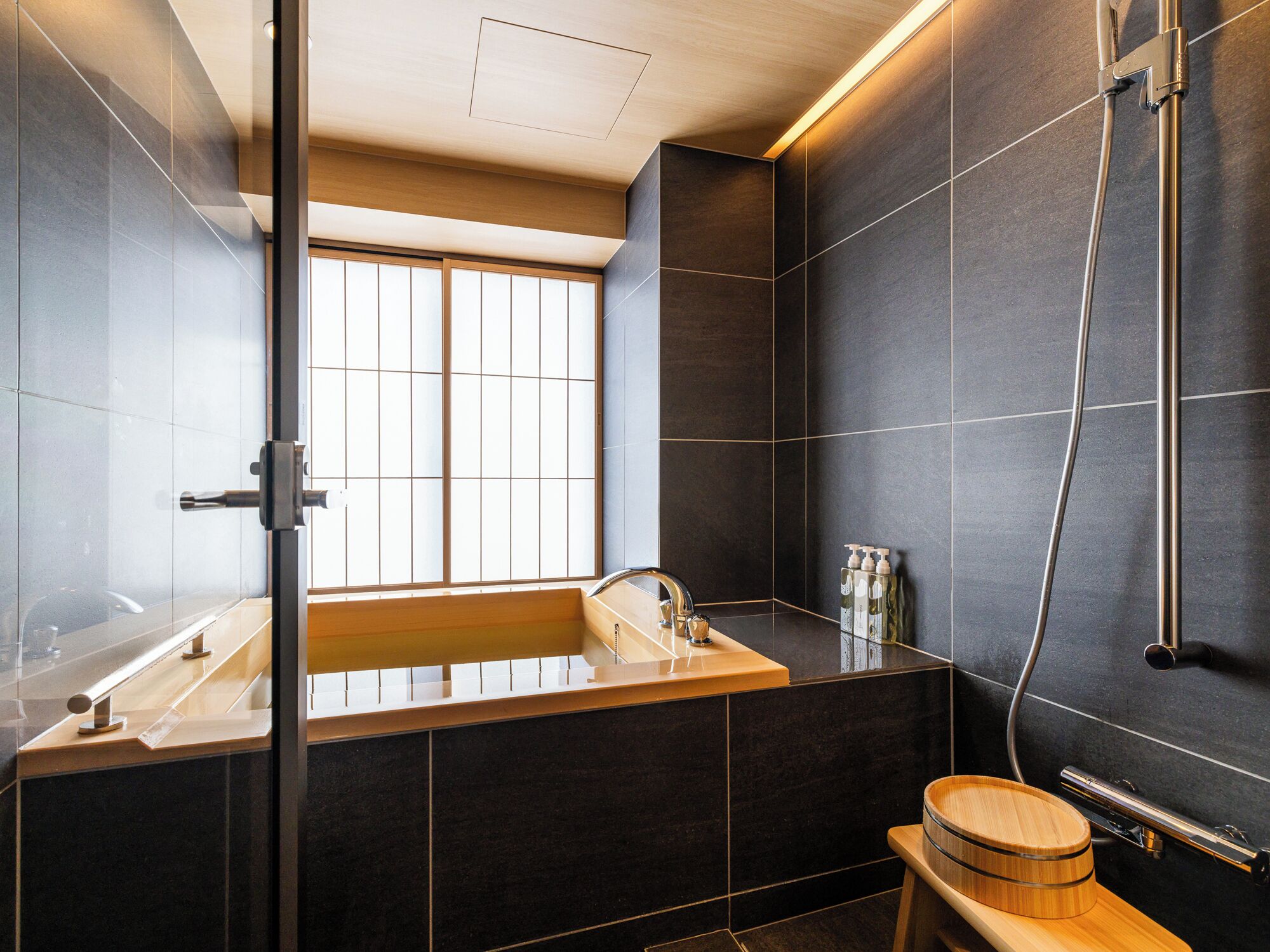 A modern bathroom with a wooden vanity, a large mirror, and a built-in shower.