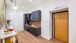 Una cocina moderna con armarios oscuros, encimera de madera y puerta de madera.
