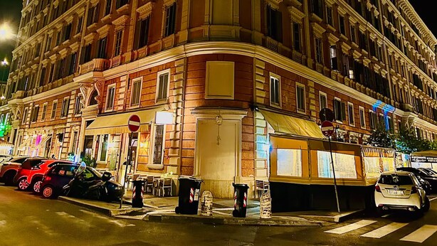 Un edificio de varios pisos con un estilo arquitectónico clásico, que destaca por una entrada en esquina y una serie de ventanas en cada planta.