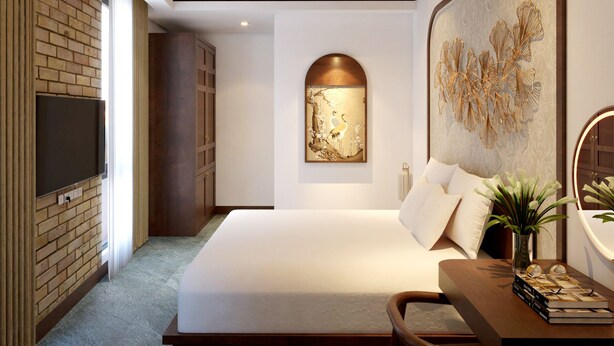 Een moderne slaapkamer met een groot bed, een flatscreen televisie aan een bakstenen muur, een plafondventilator en een decoratief wandobject.