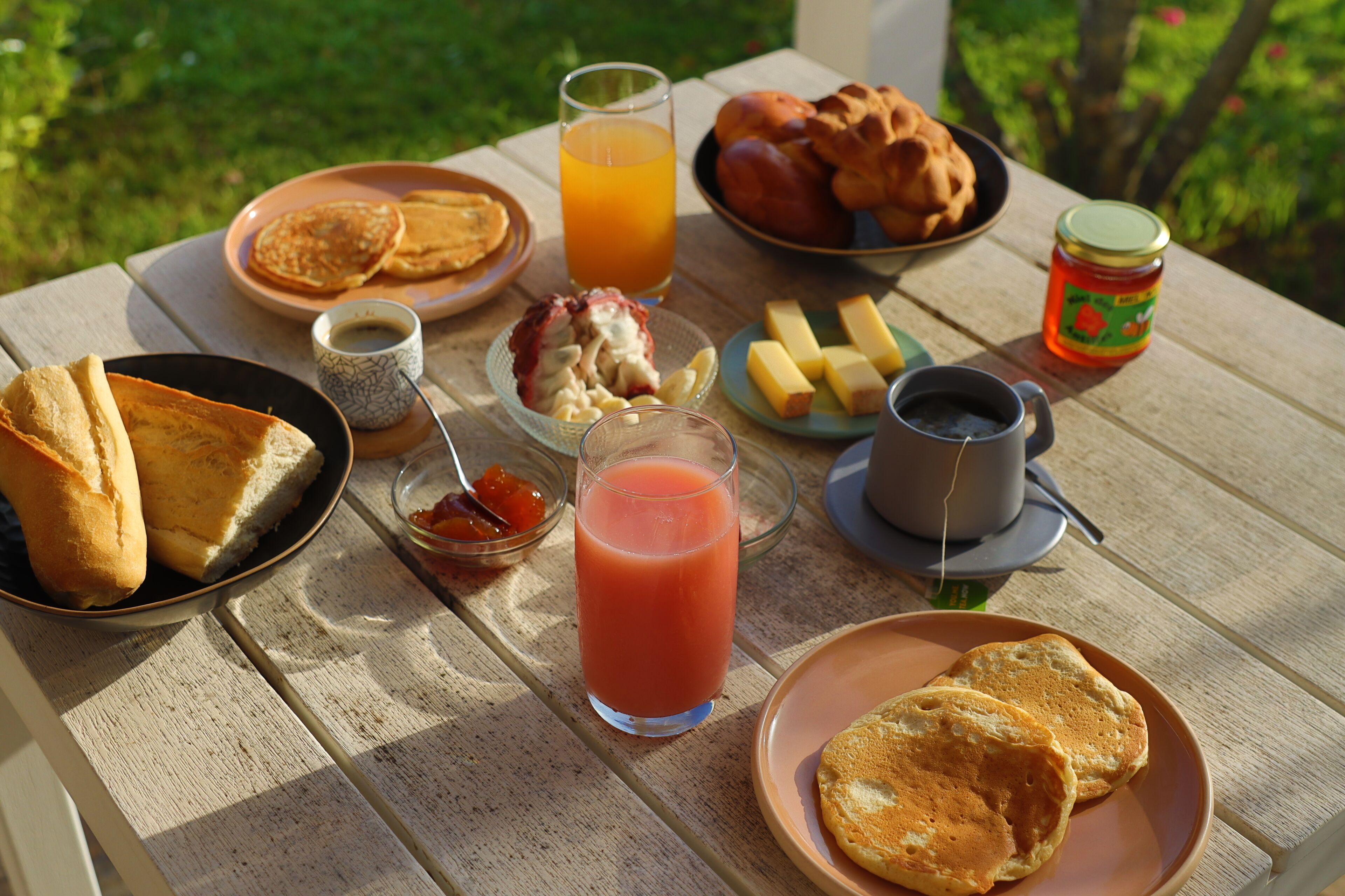 A breakfast table with various food items and drinks.