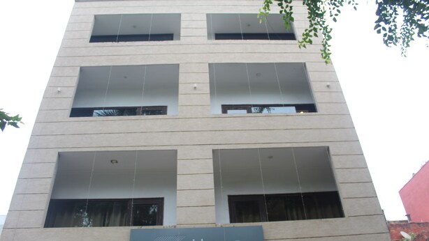 Un immeuble d’habitation de la société Khanna, avec plusieurs étages, de grandes fenêtres et une enseigne indiquant son nom.