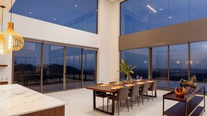 A modern dining area with a large table, chairs, and a bench. - Starlit A Luxury Hilltop Villa with Infinity Pool & Chef (Udukawa)