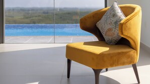A modern room with a yellow armchair and a large window offering a view of a body of water and greenery. - Starlit A Luxury Hilltop Villa with Infinity Pool & Chef (Udukawa)