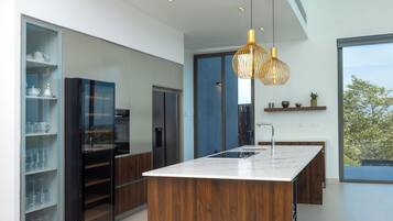 Una cucina moderna con isola centrale, elettrodomestici integrati e un'ampia finestra che offre una vista.