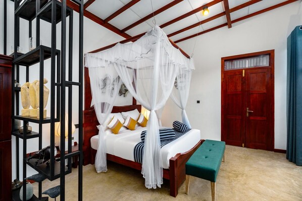 A bedroom with a four-poster canopy bed, a wooden bench, a shelf with decorative items, and a wooden door.