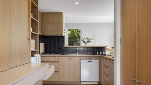 Une cuisine moderne avec des meubles en bois, un pare-feu noir et un lave-vaisselle.