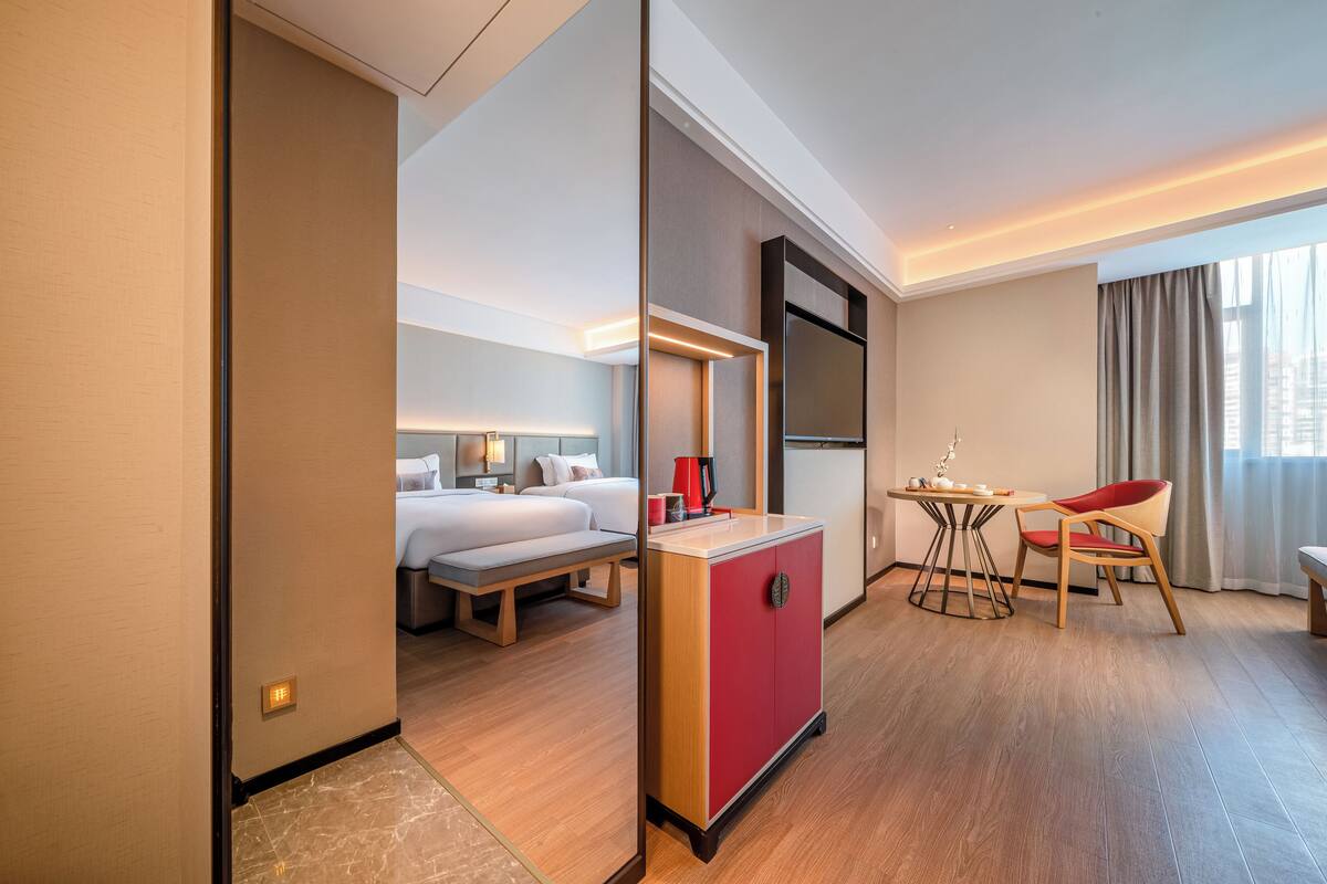Ein Hotelzimmer mit Bett, Nachttisch und Schreibtisch mit Stuhl.