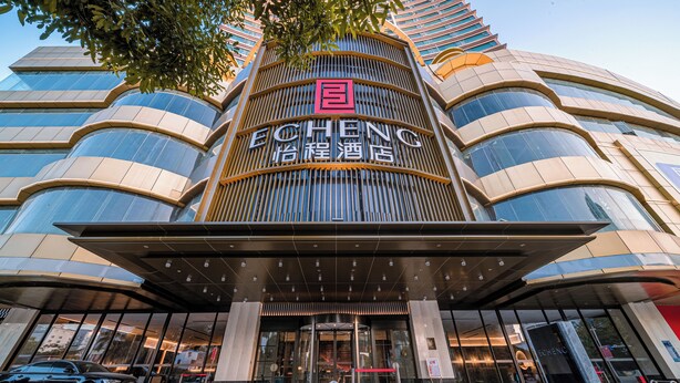 A modern hotel with a prominent entrance, large glass windows, and a distinctive logo. - Yicheng Hotel Wuzhou City Government  (Wuzhou)