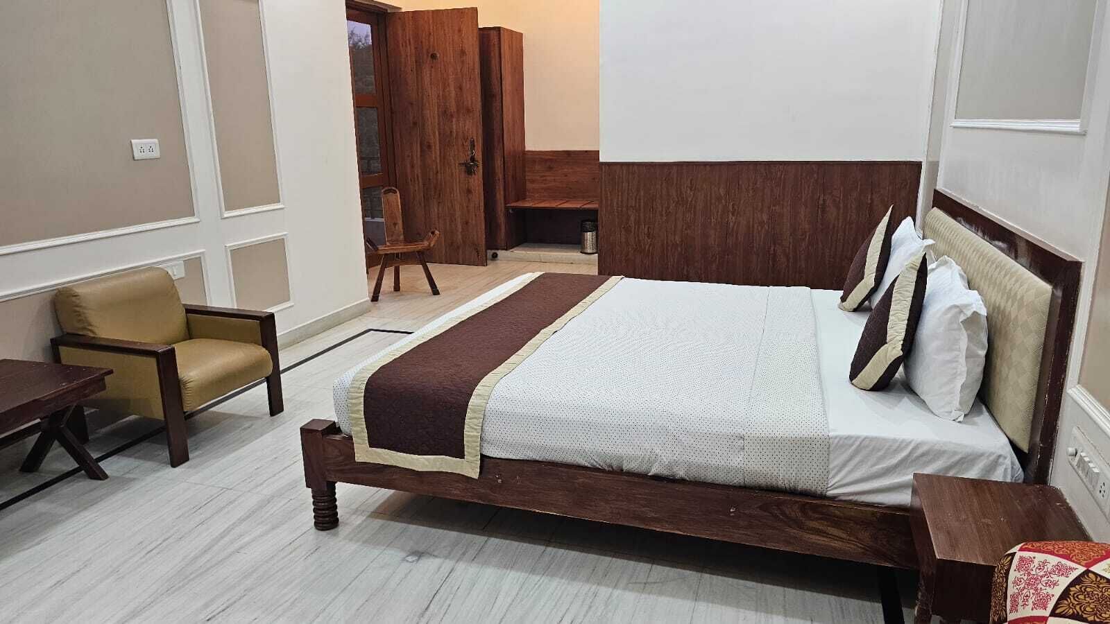 Un dormitorio ordenado con una cama de madera, una silla y un escritorio.