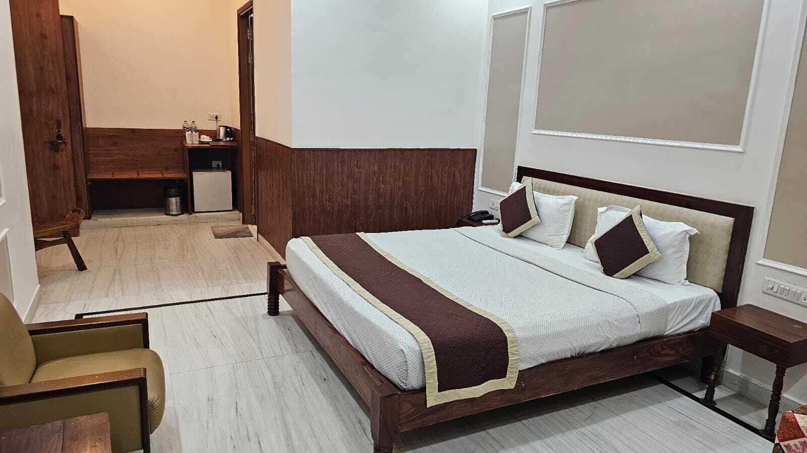 A neatly arranged bedroom with a large bed, bedside tables, and a chair.
