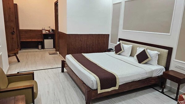 A neatly arranged bedroom with a large bed, bedside tables, and a chair.